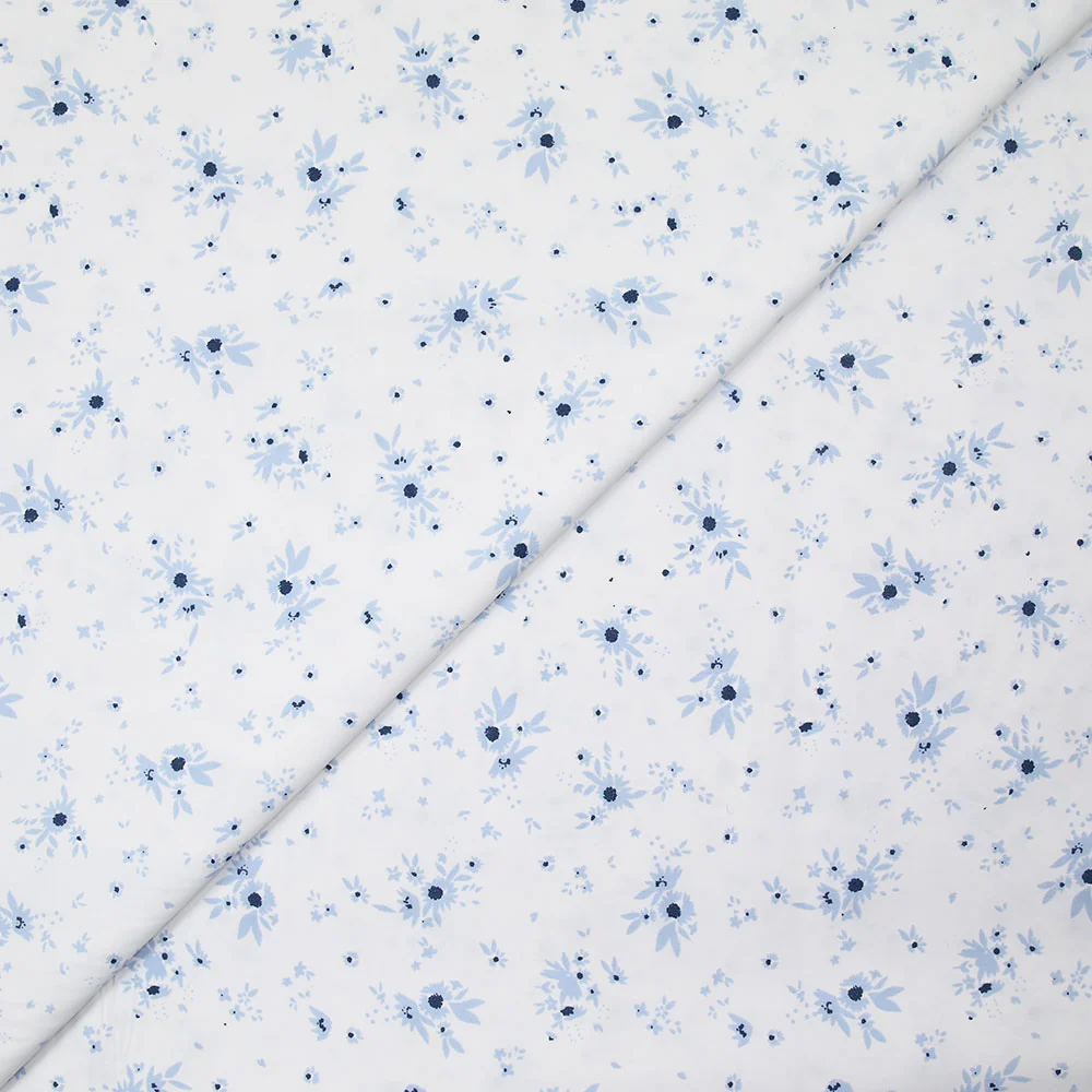 Popeline polycoton imprimée splash de fleurs bleues fond blanc